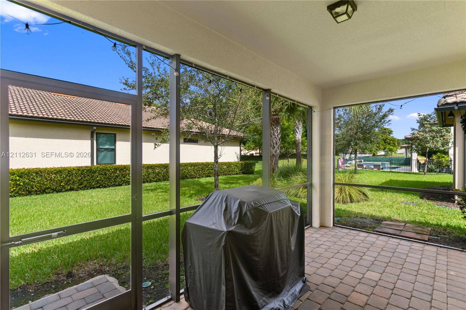8257 NW 79th Avenue, Tamarac, FL 33321 Screened-in lanai featuring paver flooring, a covered ceiling with recessed lighting, and metal framing