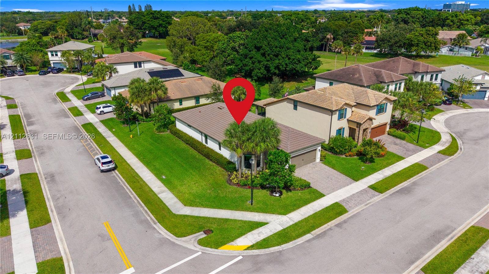 8257 NW 79th Avenue, Tamarac, FL 33321 Corner lot property featuring a multi-hipped tile roof, concrete driveway, attached garage, and manicured landscaping