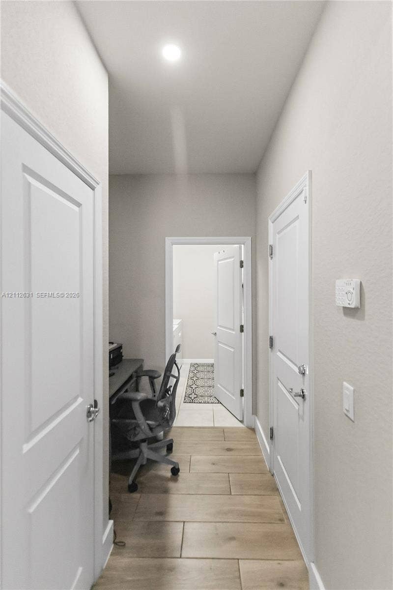 8257 NW 79th Avenue, Tamarac, FL 33321 Hallway featuring wood-finish tile flooring, recessed ceiling lighting, and multiple two-panel interior doors