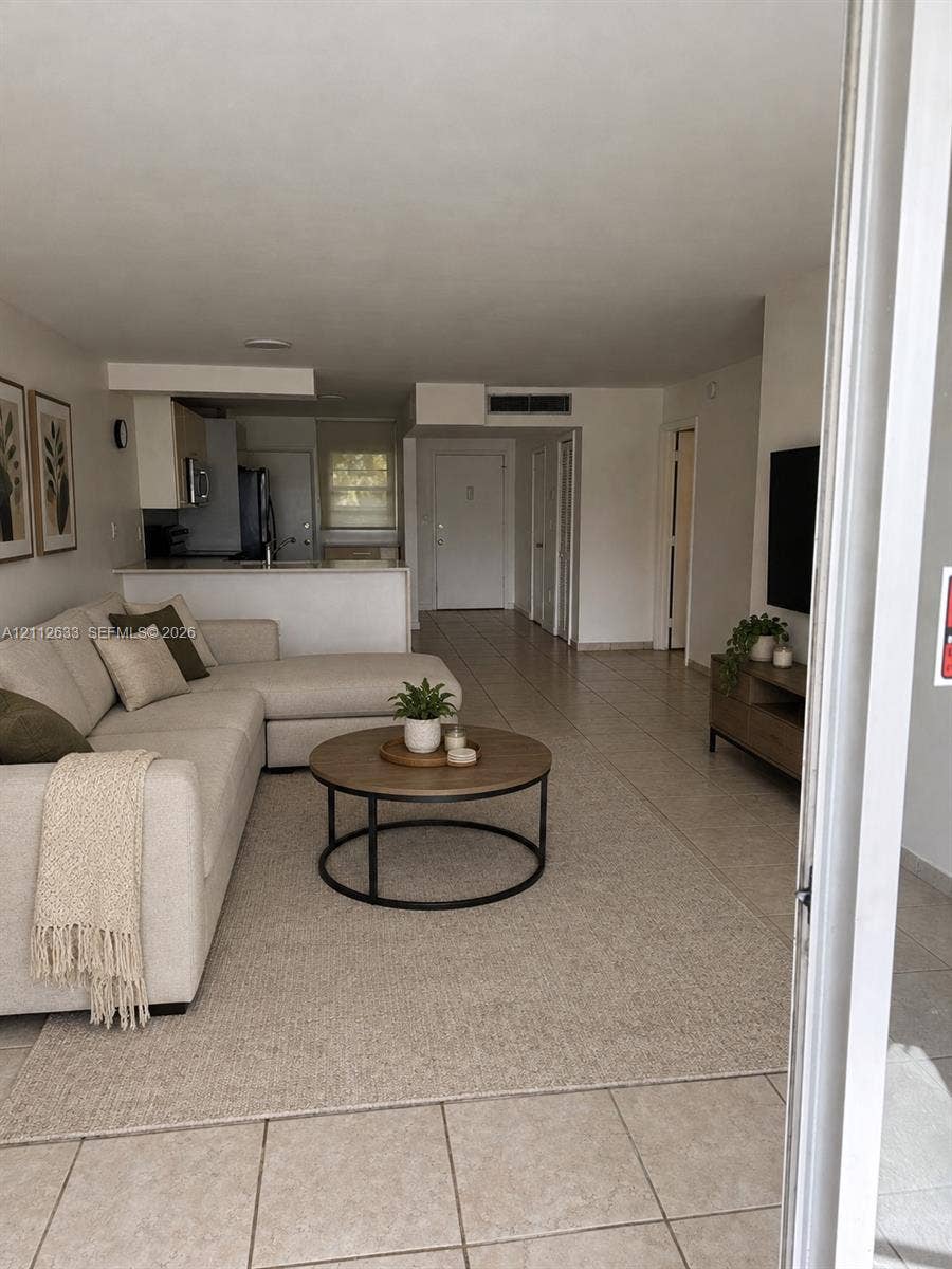 1770 NE 191st Street, #104-1, Miami, FL 33179 Open-concept floor plan featuring tile flooring, neutral wall tones, and a kitchen breakfast bar