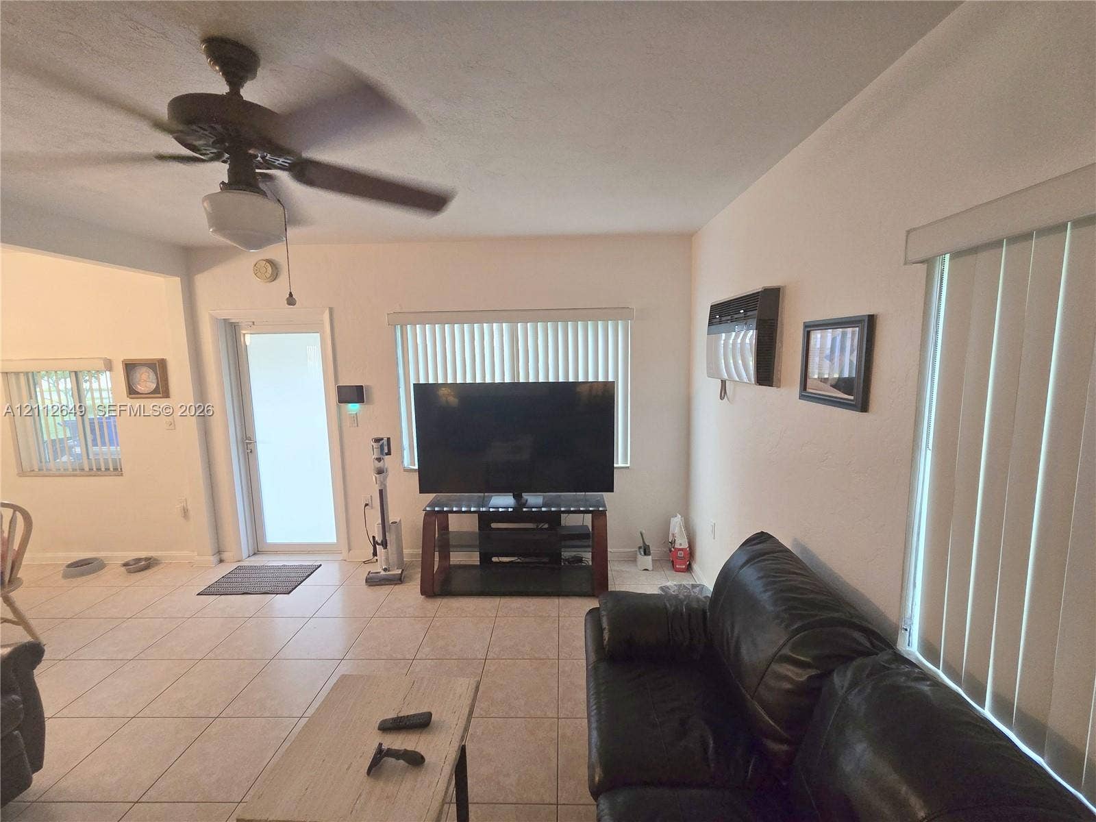 Ceramic tile flooring, ceiling fan with integrated lighting, and vertical window blinds