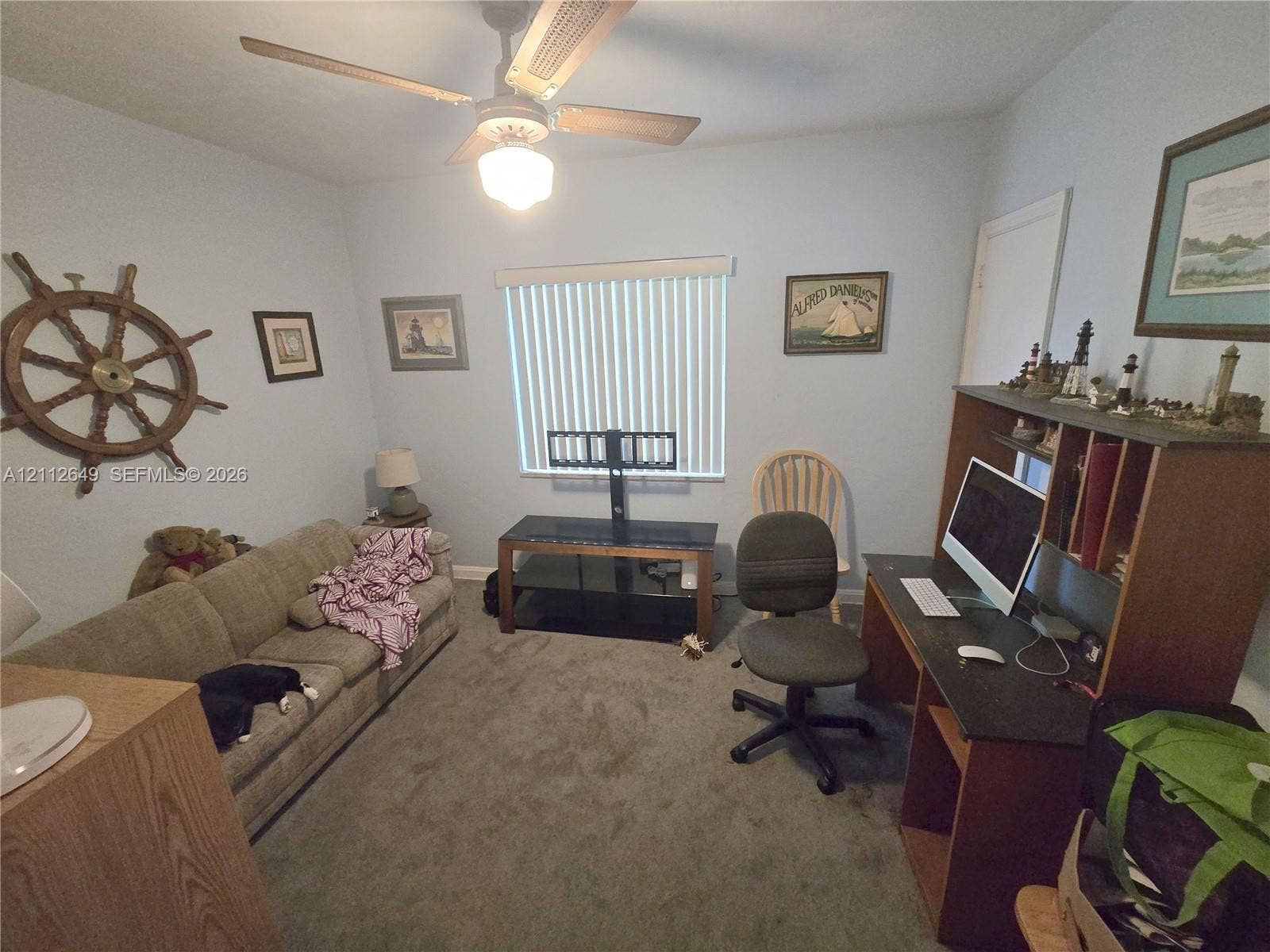 Carpeted room featuring a ceiling fan with integrated light fixture and vertical slat window blinds