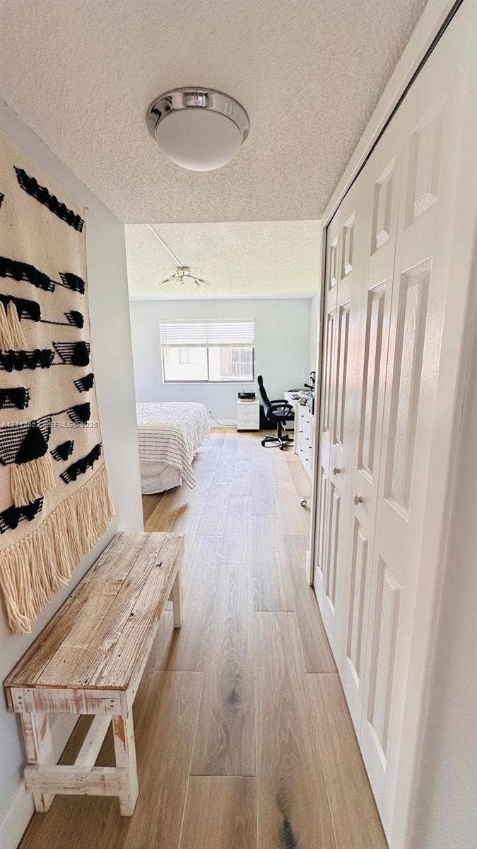 Wood-finish flooring, multi-panel closet doors, and a flush-mount dome light fixture