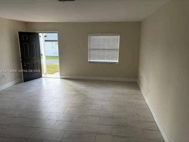 Neutral-toned walls, tile flooring, and a window with horizontal blinds