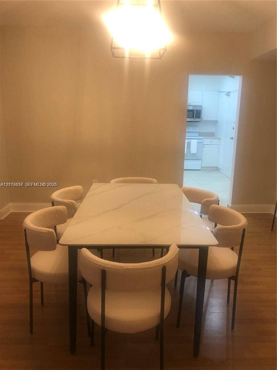 10185 Collins Avenue, #1016, Bal Harbour, Bal Harbour, FL 33154 Dining area featuring wood-finish flooring and a geometric pendant light fixture
