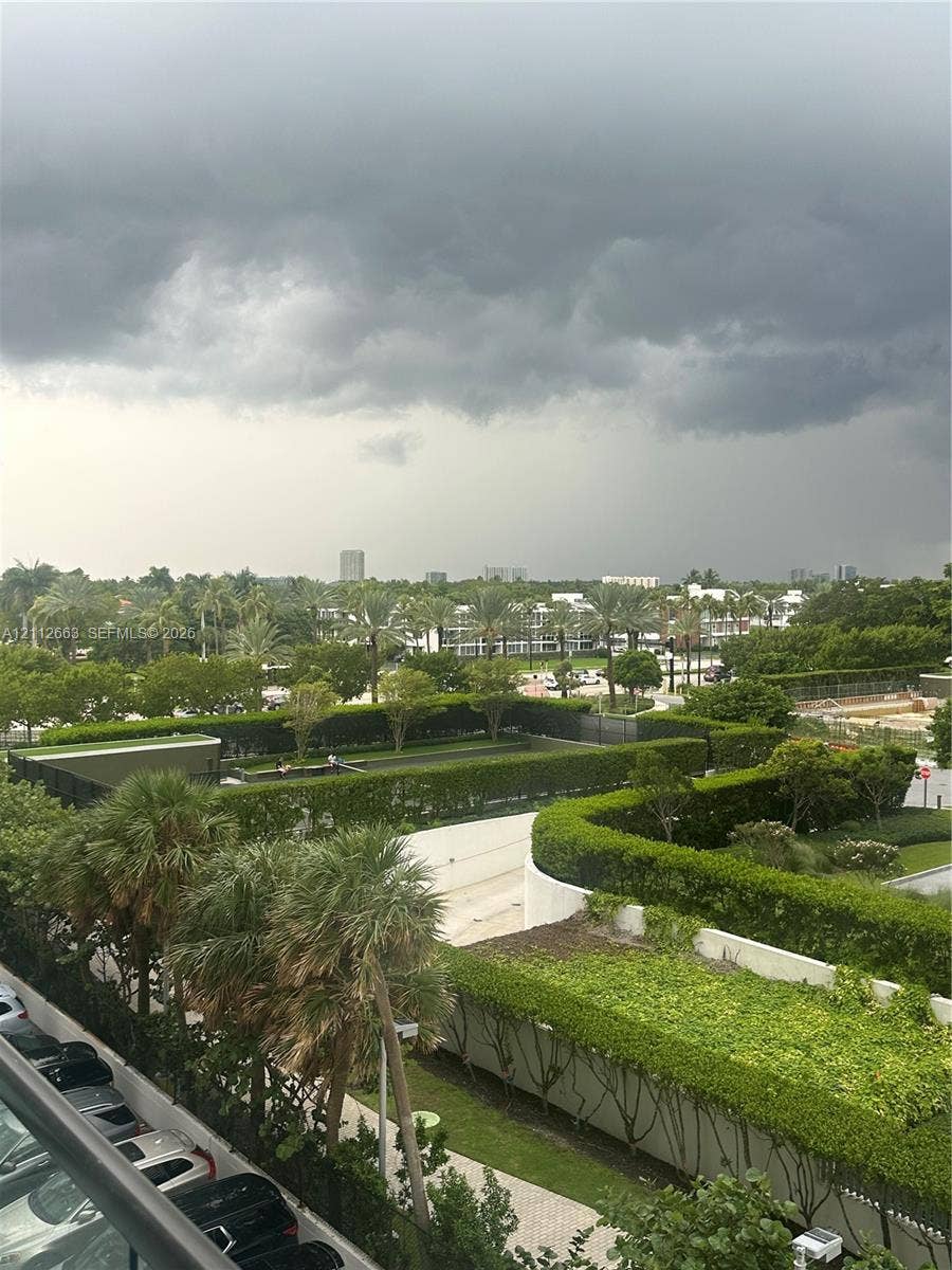 10185 Collins Avenue, #523, Bal Harbour, Bal Harbour, FL 33154 Exterior grounds featuring manicured hedges, mature palm trees, paved walkways, and a fenced recreation area