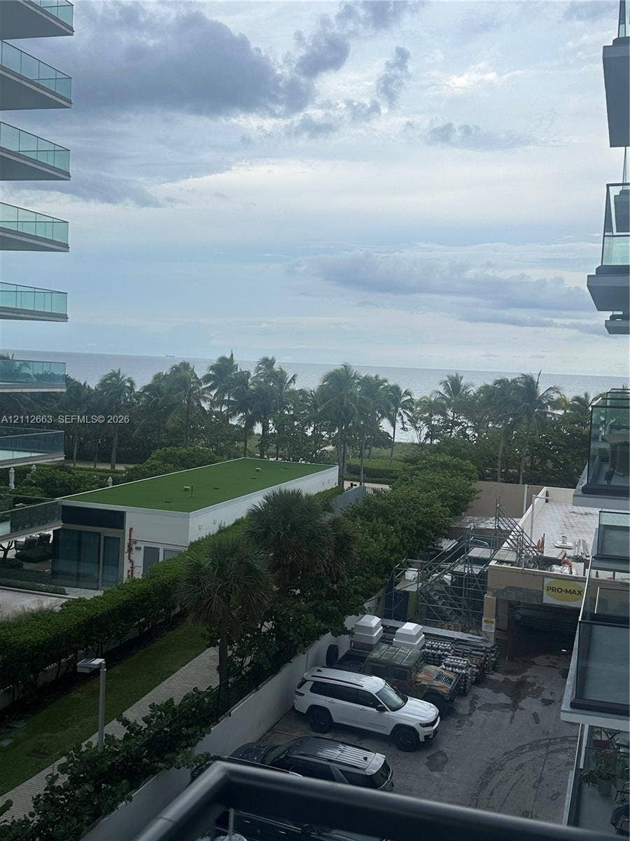 10185 Collins Avenue, #523, Bal Harbour, Bal Harbour, FL 33154 Balcony featuring glass railings and an expansive horizon line including ocean and coastal greenery