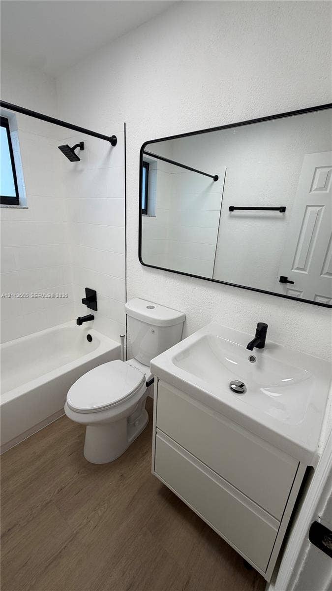3314 NW 8th, #2, Miami, Miami, FL 33131 Bathroom featuring a vanity with integrated sink, black matte hardware, framed mirror, and wood-finish flooring