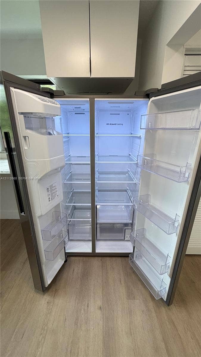 3314 NW 8th, #2, Miami, Miami, FL 33131 Stainless steel side-by-side refrigerator featuring adjustable glass shelving, clear storage drawers, integrated door shelving, and an in-door water and ice dispensing system