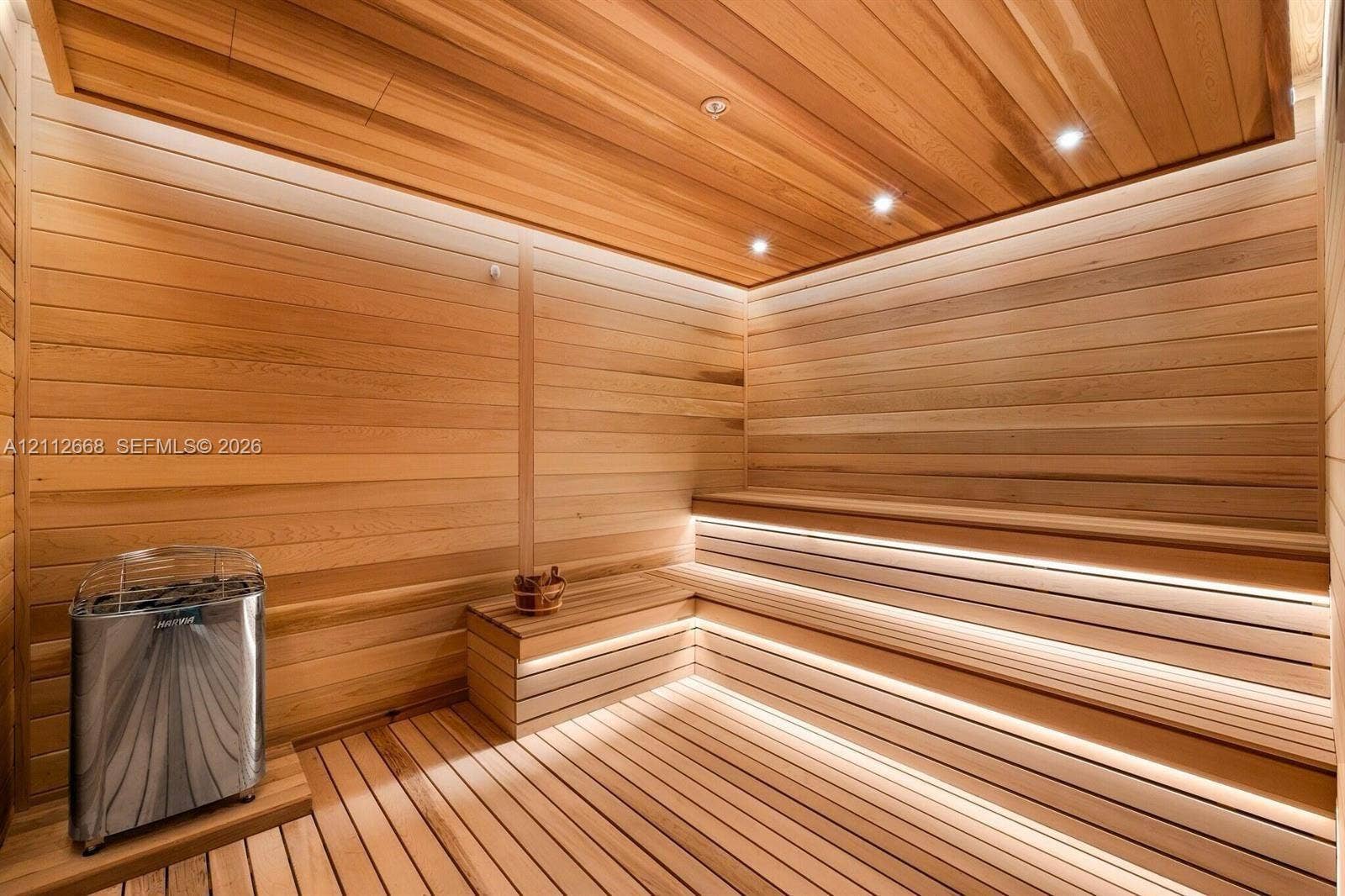 1400 Biscayne Boulevard, #1803, Miami, Miami, FL 33132 Sauna featuring light-toned wood wall and ceiling paneling, multi-level bench seating, integrated strip lighting, and a metal sauna heater