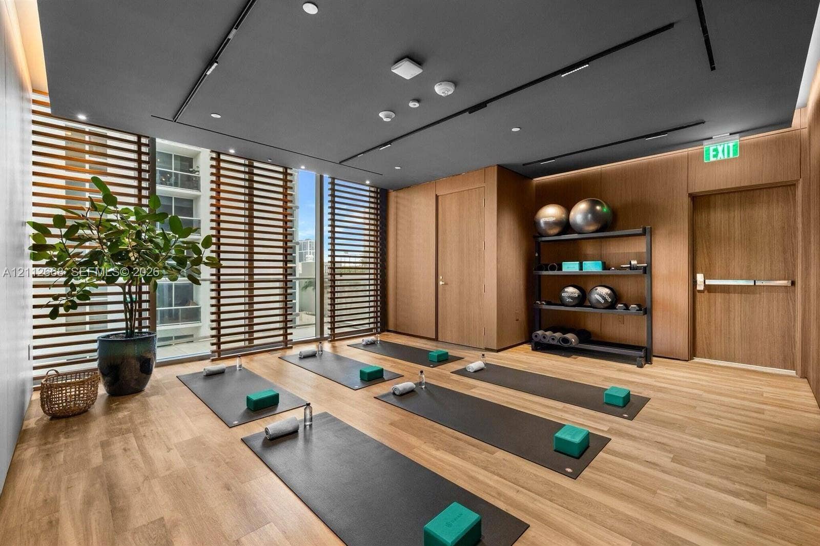 1400 Biscayne Boulevard, #1803, Miami, Miami, FL 33132 Fitness room featuring wood-finish flooring, wood-paneled walls, floor-to-ceiling slatted privacy screens, and a recessed ceiling with integrated linear lighting