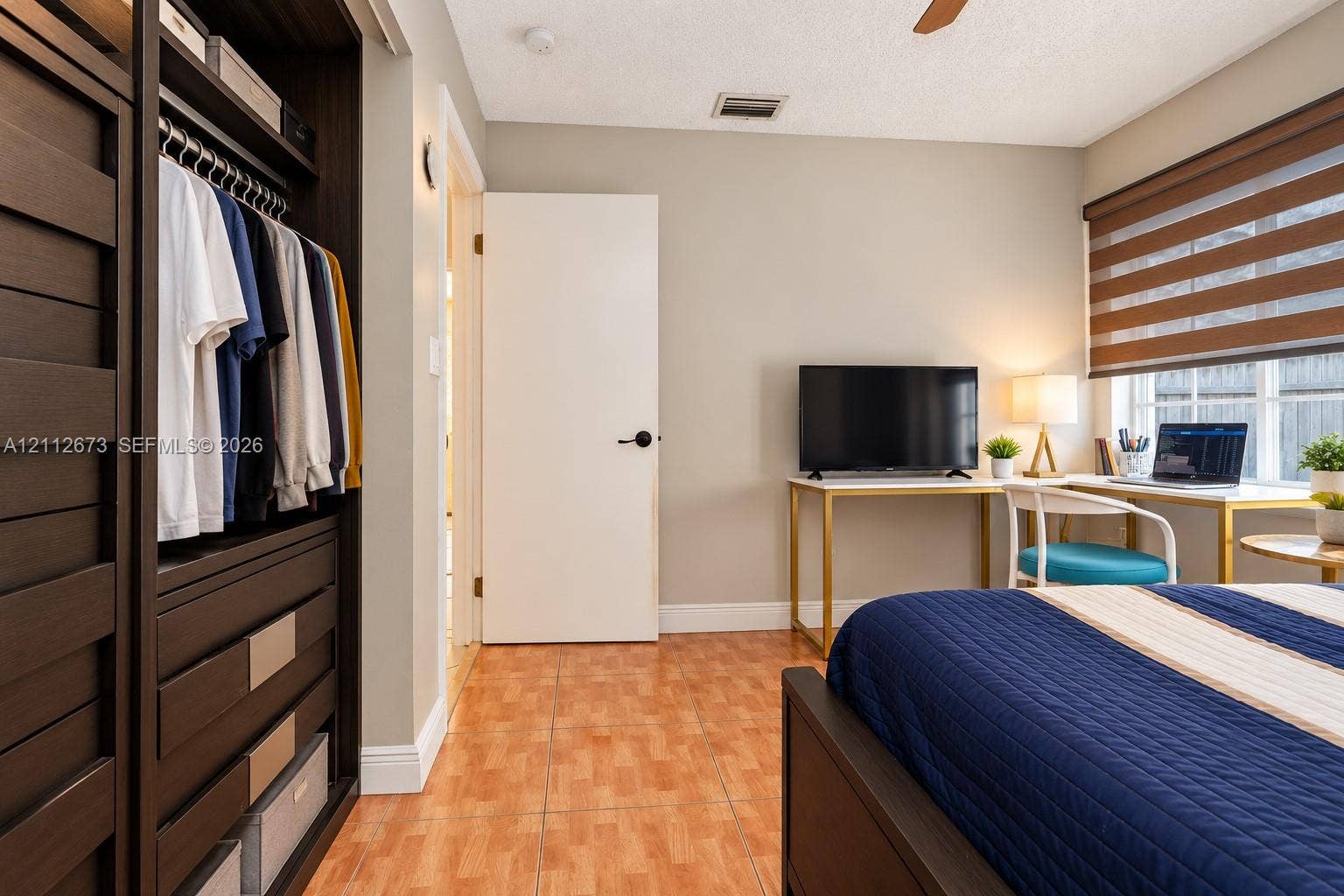 10225 SW 141st Court, #0, Miami, Miami, FL 33186 Built-in dark wood-finish cabinetry, neutral wall paint, tile flooring, and multi-layered window shades
