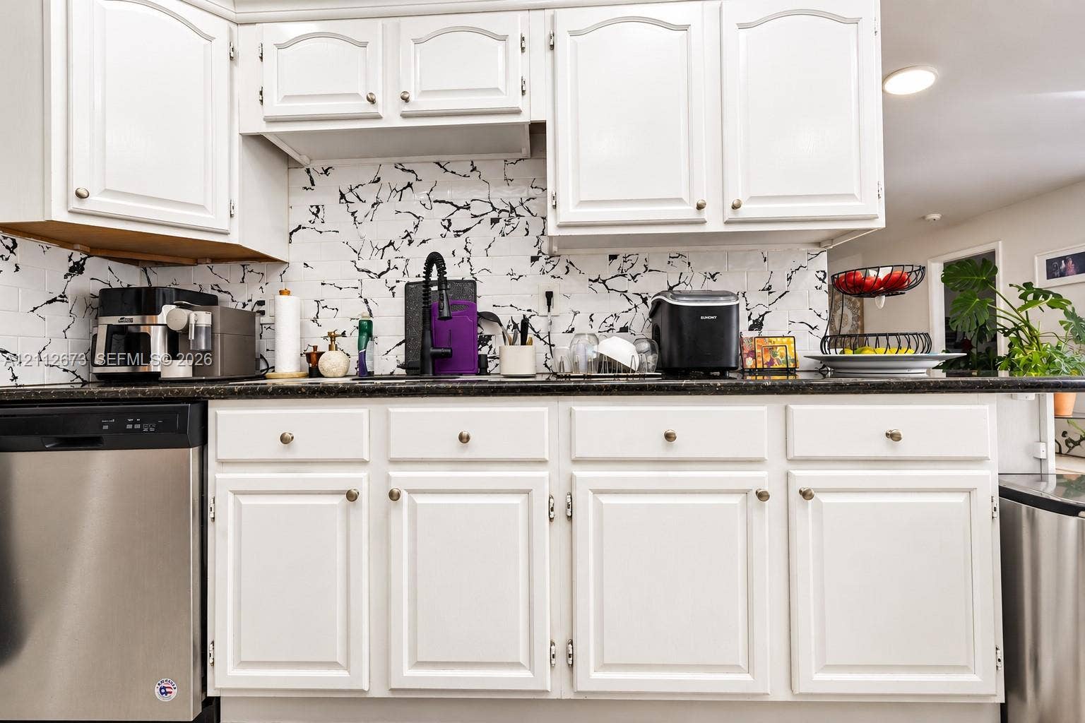 10225 SW 141st Court, #0, Miami, Miami, FL 33186 White raised-panel cabinetry, dark stone-finish countertops, high-contrast patterned backsplash, and stainless steel dishwasher