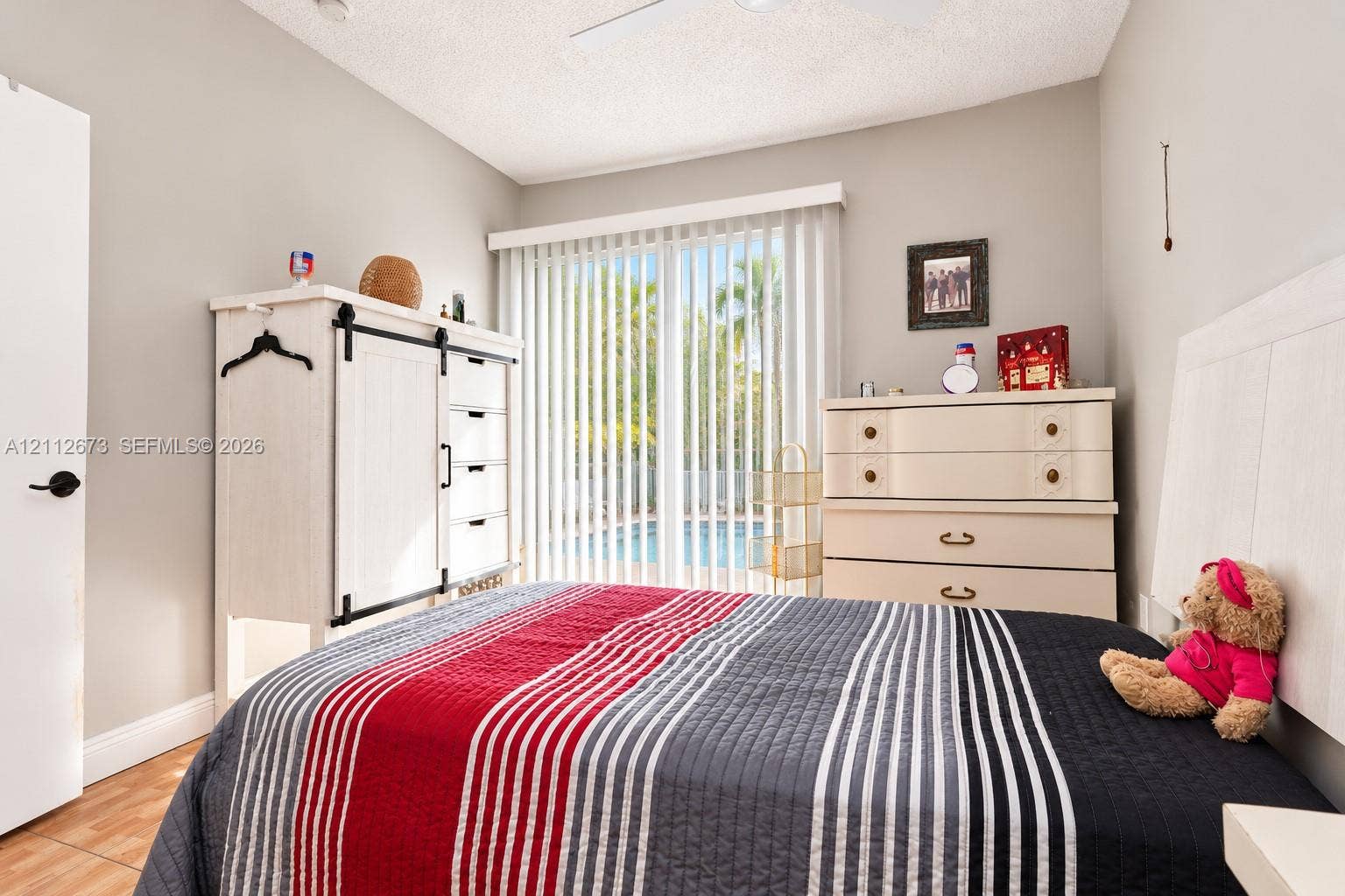 10225 SW 141st Court, #0, Miami, Miami, FL 33186 Bedroom featuring vertical sliding glass doors, neutral wall paint, tile flooring, and a ceiling-mounted fan