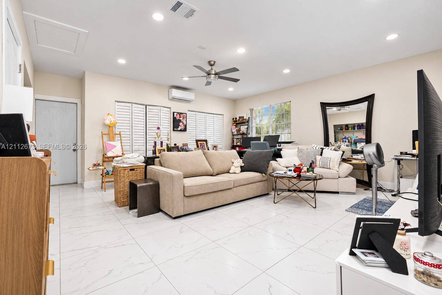 10225 SW 141st Court, #0, Miami, Miami, FL 33186 Living area featuring large-format tile flooring, recessed lighting, a ceiling fan, white louvered window shutters, and a wall-mounted ductless climate control unit