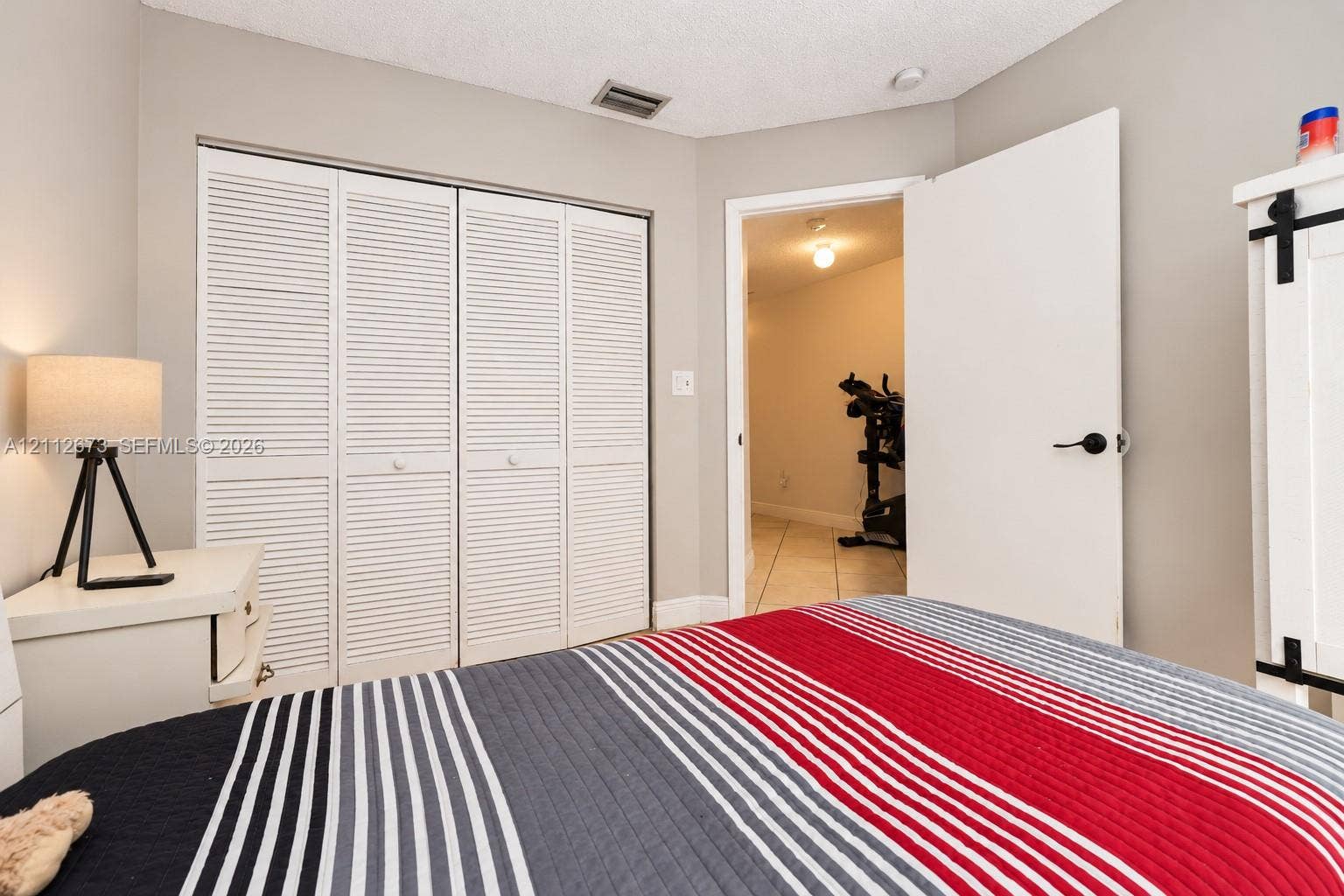 10225 SW 141st Court, #0, Miami, Miami, FL 33186 Room featuring four-panel louvered closet doors and a solid core interior door with matte black hardware
