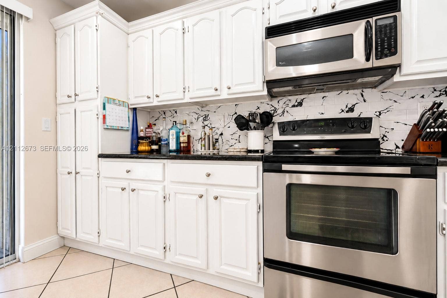 10225 SW 141st Court, #0, Miami, Miami, FL 33186 Kitchen featuring white cabinetry, dark countertops, a patterned tile backsplash, and stainless steel appliances