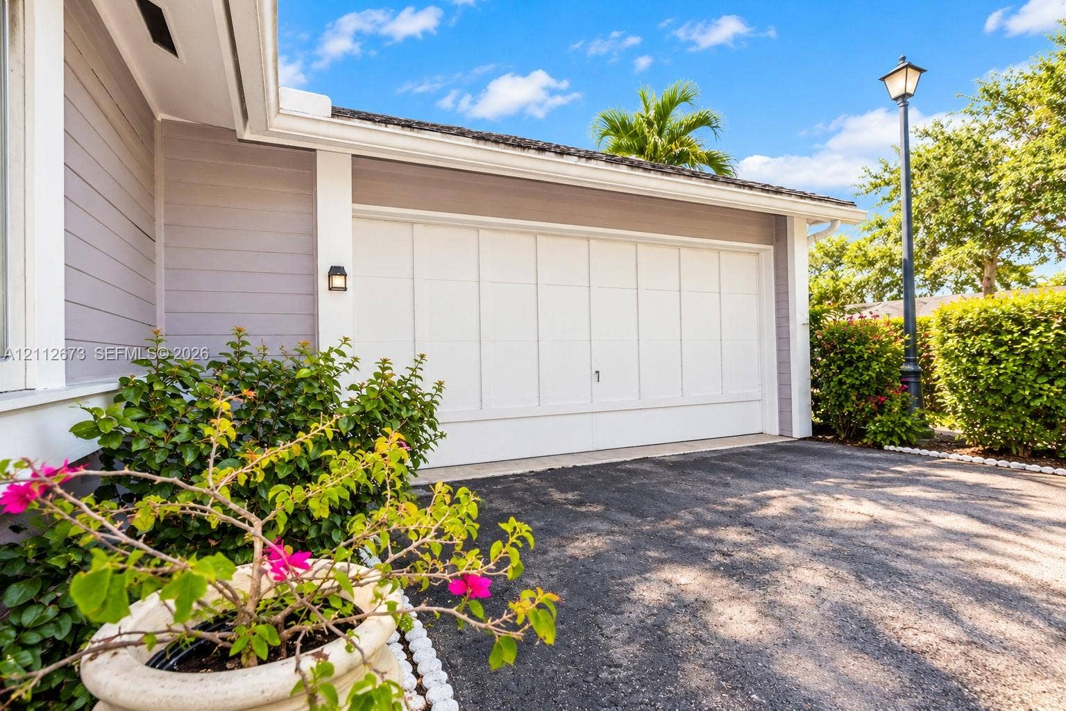 10225 SW 141st Court, #0, Miami, Miami, FL 33186 Exterior featuring horizontal siding, multi-panel garage door, attached wall-mounted light fixture, and paved driveway