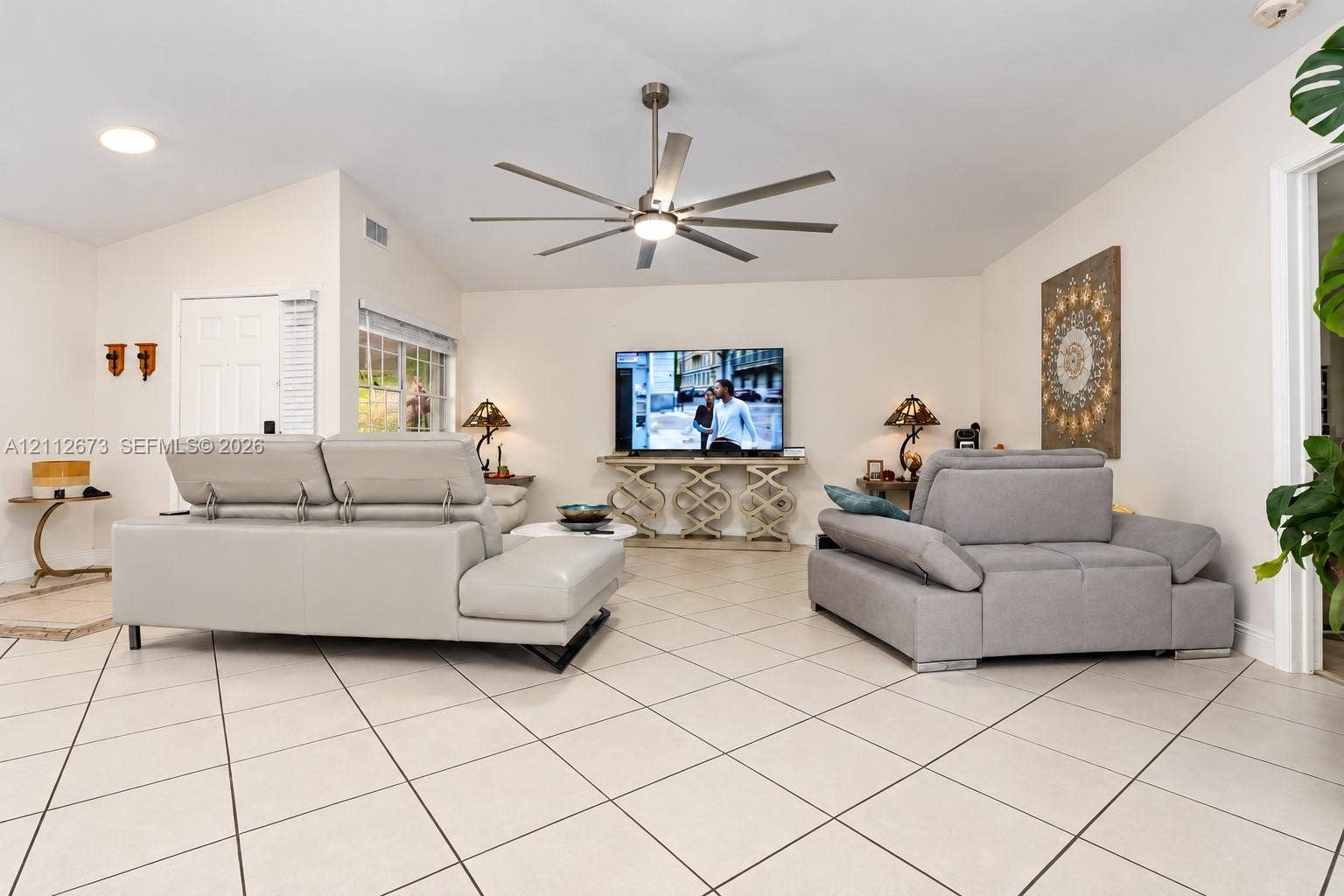 10225 SW 141st Court, #0, Miami, Miami, FL 33186 Open-concept room featuring a vaulted ceiling, large-format tile flooring, and a central multi-blade ceiling fan with integrated lighting