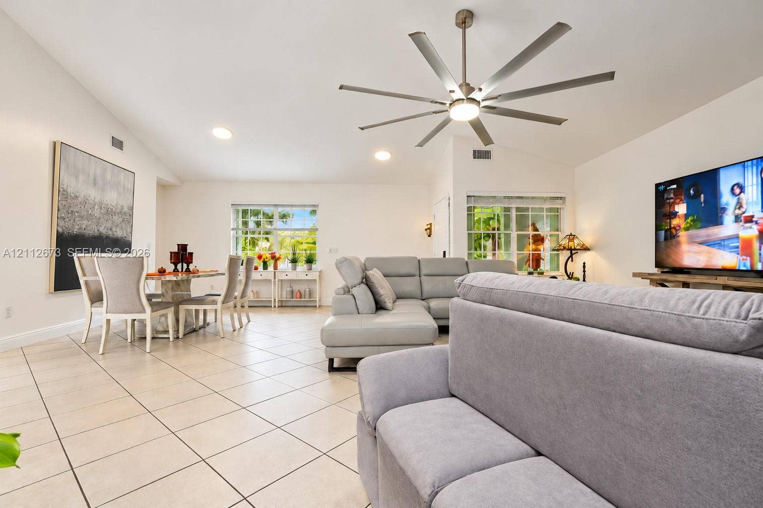10225 SW 141st Court, #0, Miami, Miami, FL 33186 Vaulted ceilings featuring a multi-blade brushed metal ceiling fan and recessed lighting, finished with light-toned ceramic tile flooring and multi-pane windows