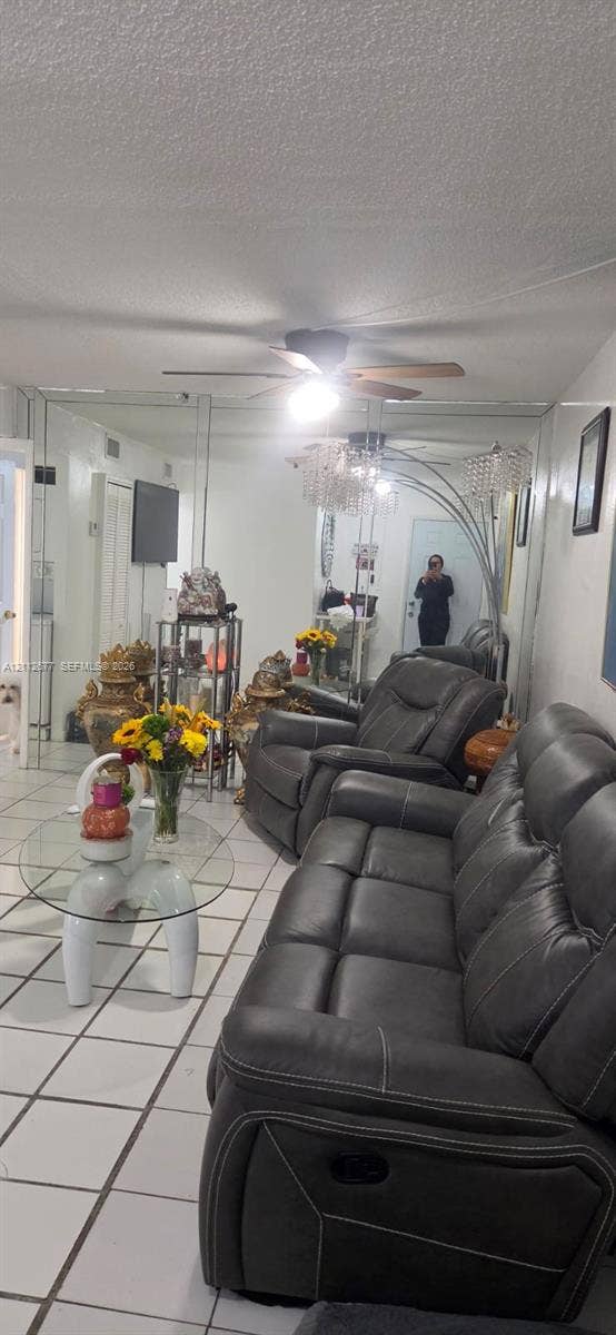 6675 W 4th Avenue, #206, Hialeah, FL 33012 Floor-to-ceiling wall mirrors, white ceramic tile flooring, and a ceiling-mounted fan with integrated lighting