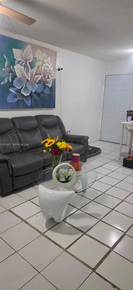 6675 W 4th Avenue, #206, Hialeah, FL 33012 Ceramic tile flooring throughout with a six-panel entry door and ceiling-mounted fan
