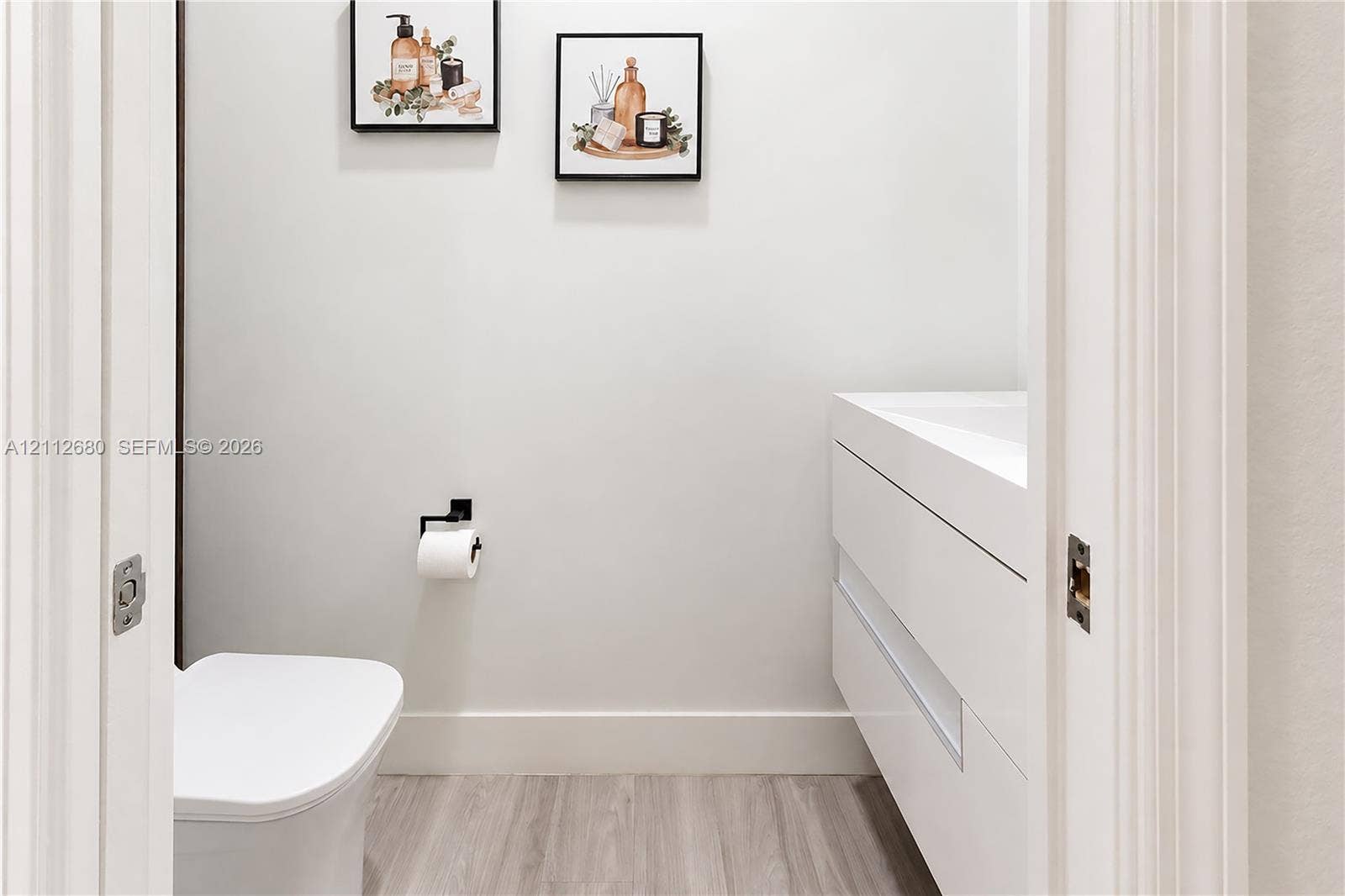 890 SW 154th Path, Miami, FL 33194 Floating vanity with integrated sink, wood-finish flooring, and matte black hardware