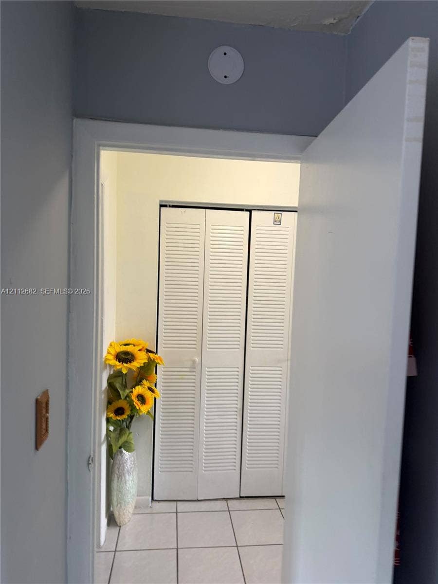 1655 W 44th Place, #435, Hialeah, FL 33012 White louvered bifold closet doors and tiled flooring