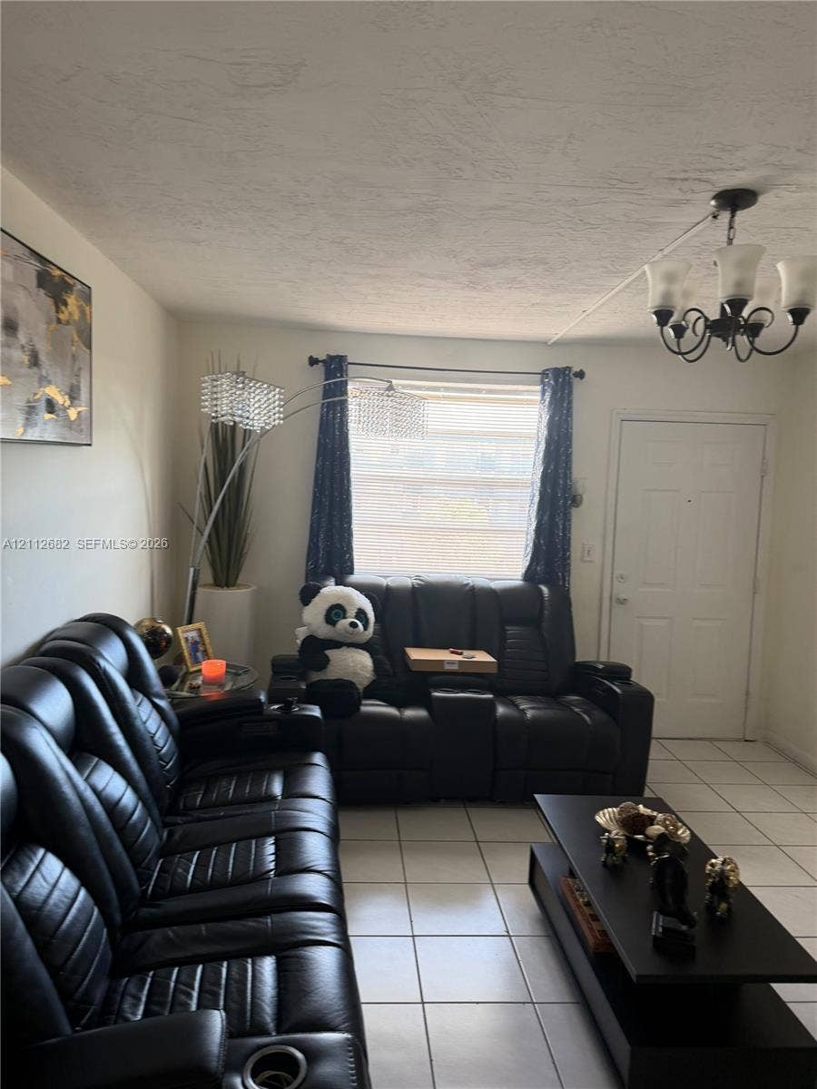 1655 W 44th Place, #435, Hialeah, FL 33012 Room featuring white tile flooring, a multi-arm chandelier with frosted glass shades, and a large window