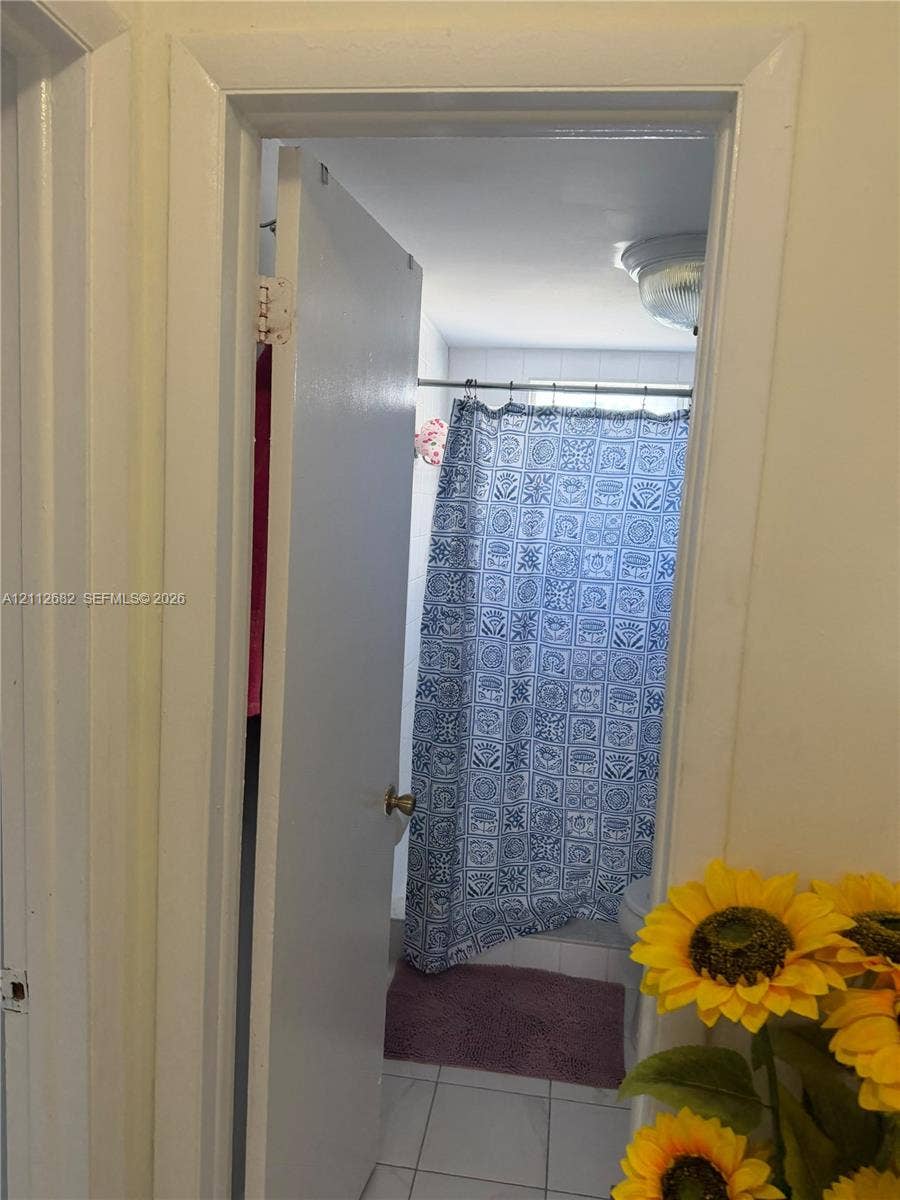 1655 W 44th Place, #435, Hialeah, FL 33012 Enclosed room featuring a neutral-toned door, white-framed doorway, and tile flooring