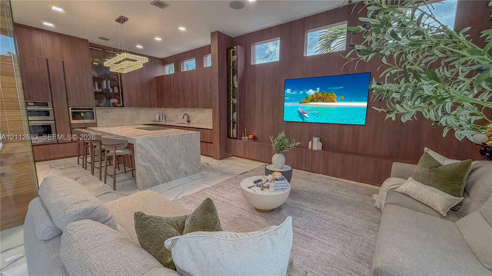 Open concept room featuring floor-to-ceiling wood-panelled walls, an expansive stone kitchen island, recessed lighting, clerestory windows, and built-in stainless steel appliances