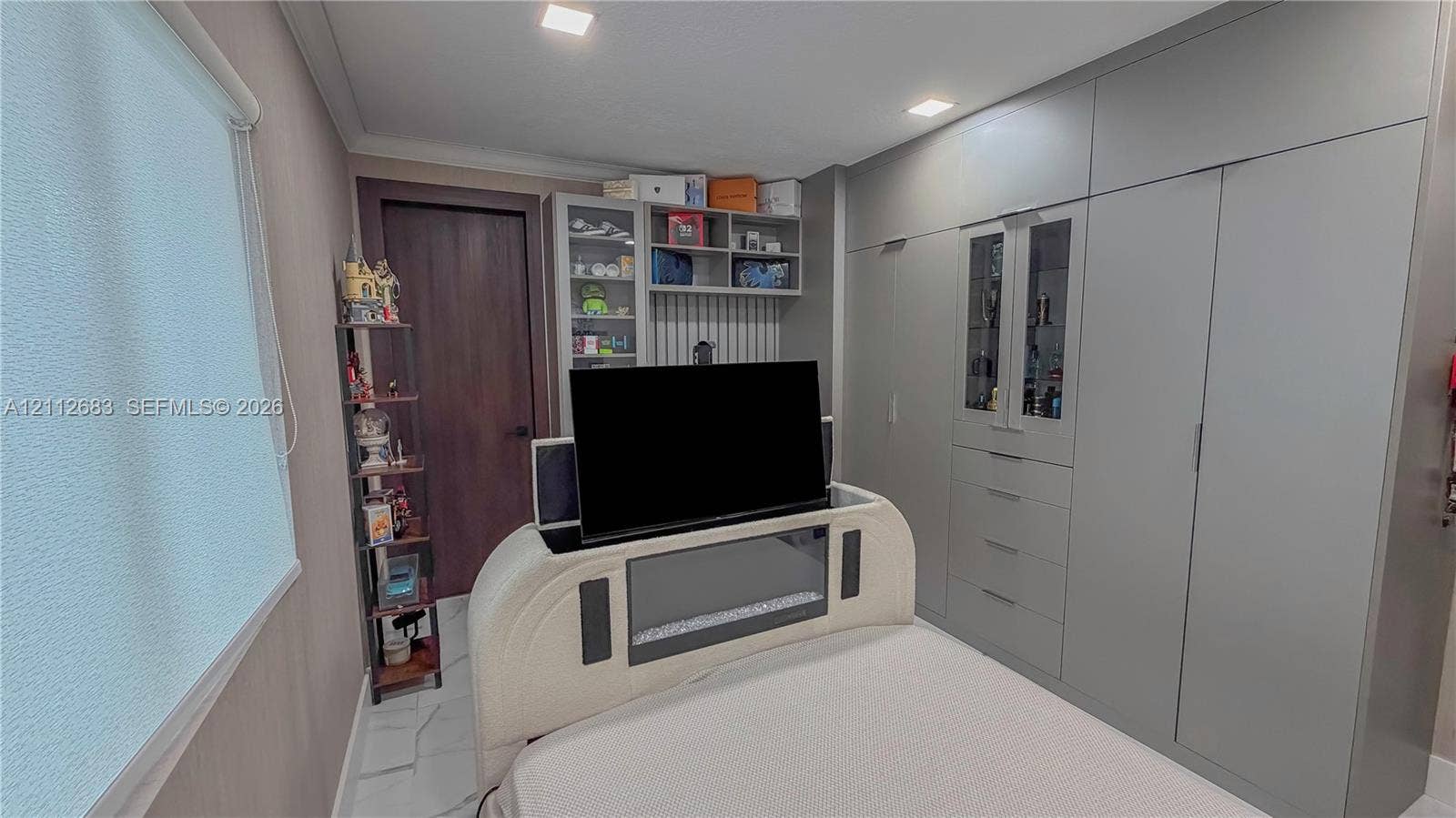 Built-in full-height cabinetry with integrated shelving, flush-panel doors, and recessed lighting