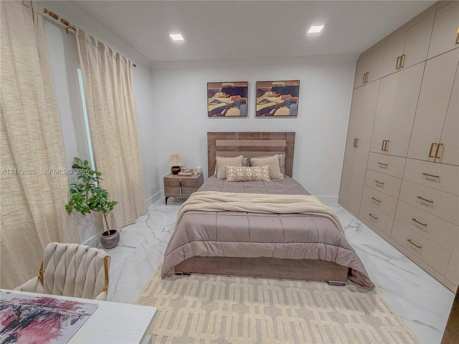 Floor-to-ceiling built-in cabinetry with integrated drawers and brass-tone hardware, stone-finish flooring, and recessed lighting
