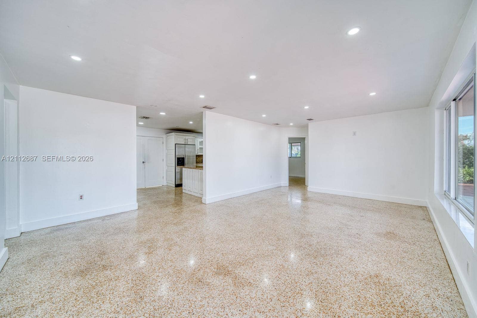 9340 SW 26th Street, Miami, FL 33165 Open-concept interior featuring polished aggregate flooring, recessed lighting, and large-format sliding windows