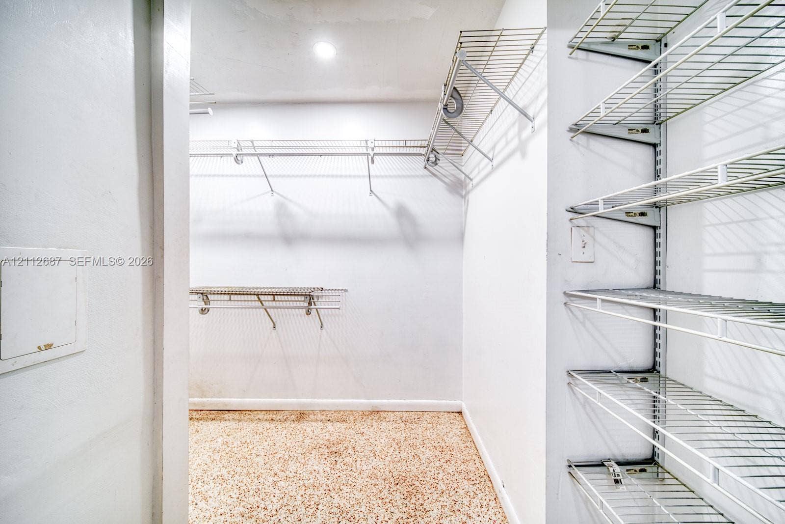 9340 SW 26th Street, Miami, FL 33165 Walk-in storage space featuring multi-tiered white wire shelving systems and speckled composite flooring