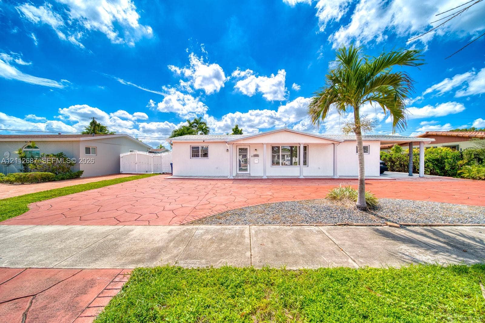 9340 SW 26th Street, Miami, FL 33165 Single-story exterior featuring a stamped concrete driveway, covered parking area, and decorative rock landscaping
