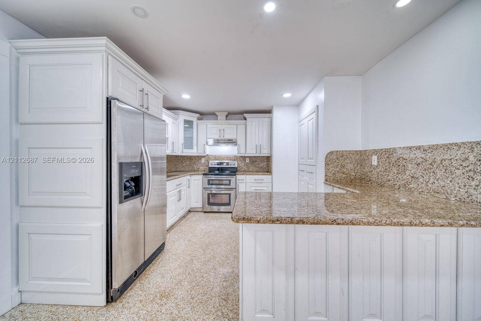 9340 SW 26th Street, Miami, FL 33165 Kitchen featuring custom white cabinetry, stone countertops with matching backsplash, stainless steel appliances, and recessed lighting