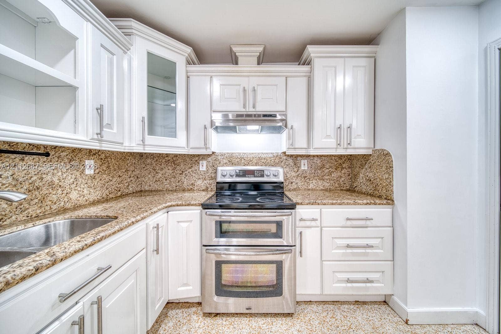 9340 SW 26th Street, Miami, FL 33165 Kitchen featuring white shaker-style cabinetry, stone-finish countertops with matching backsplash, stainless steel double-oven range, and an undermount sink