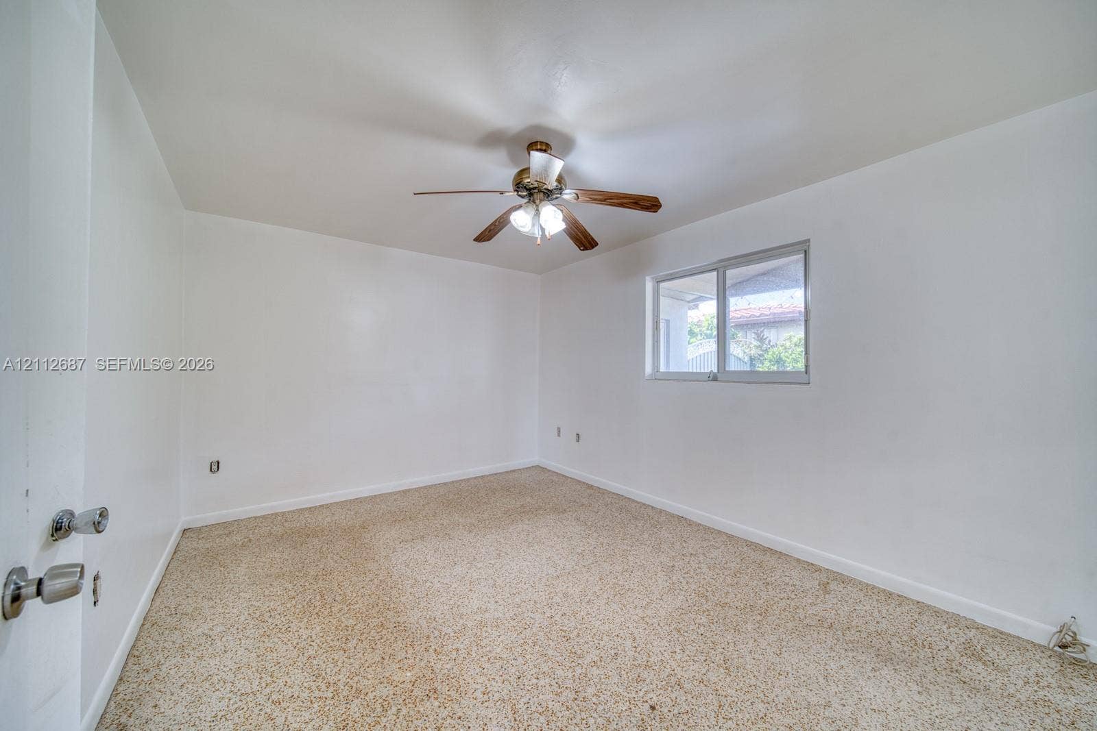 9340 SW 26th Street, Miami, FL 33165 Room featuring neutral wall finishes, carpeting, a ceiling-mounted light fixture with a fan, and a single-pane sliding window