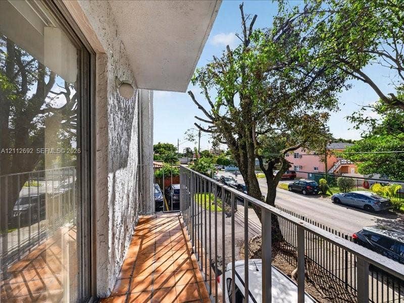 1111 NW 19th Avenue, #205, Miami, FL 33125 Private balcony featuring terracotta tile flooring, metal railing, and stucco exterior wall