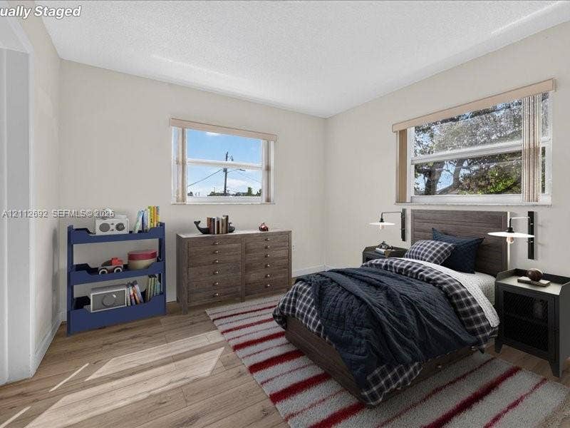 1111 NW 19th Avenue, #205, Miami, FL 33125 Wood-finish flooring, dual windows with neutral-tone blinds, and wall-mounted swing-arm light fixtures