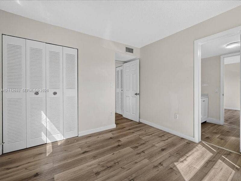 1111 NW 19th Avenue, #205, Miami, FL 33125 Wood-finish flooring, multi-panel interior doors, and a four-panel louvered closet door