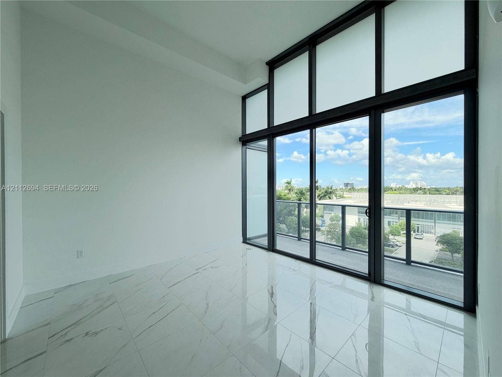1170 E Hallandale Beach Boulevard, #503, Hallandale Beach, Hallandale Beach, FL 33009 Floor-to-ceiling windows with black metal framing, polished white tile flooring, and integrated glass balcony door