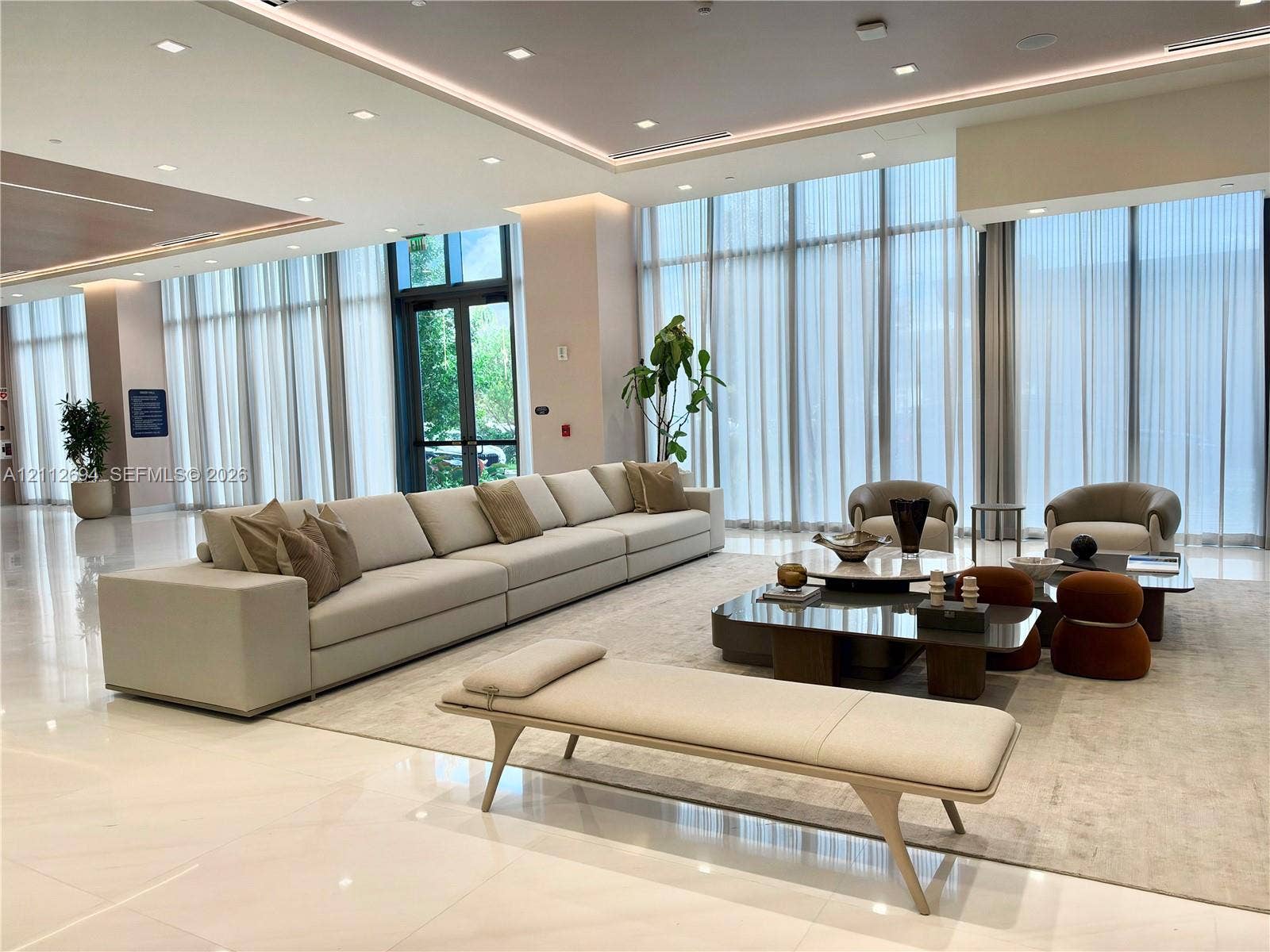 1170 E Hallandale Beach Boulevard, #503, Hallandale Beach, Hallandale Beach, FL 33009 Expansive common area featuring floor-to-ceiling windows, polished tile flooring, recessed cove lighting, and drop ceiling details