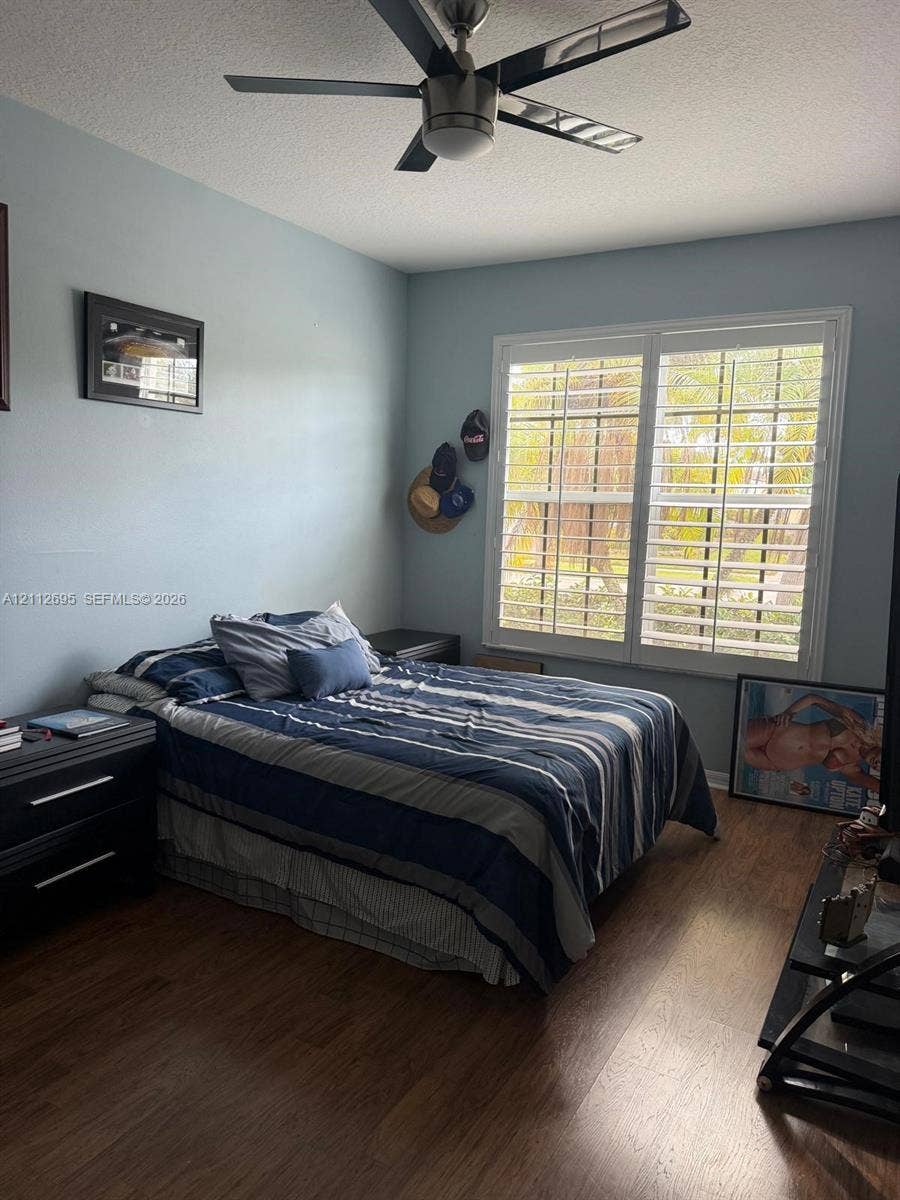 9812 SW Glenbrook Drive, Port St Lucie, FL 34987 Wood-finish flooring, plantation shutters, and a multi-blade ceiling fan with integrated lighting