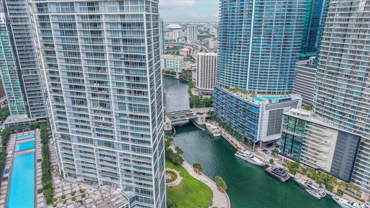 475 Brickell Avenue, #4511, Miami, FL 33131 High-rise residential tower featuring floor-to-ceiling glass windows, private balconies, and proximity to a waterway with boat slips and a swimming pool