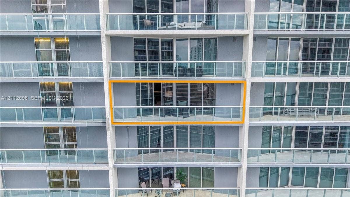 475 Brickell Avenue, #4511, Miami, FL 33131 High-rise exterior featuring floor-to-ceiling glass paneling and a private balcony with metal railings