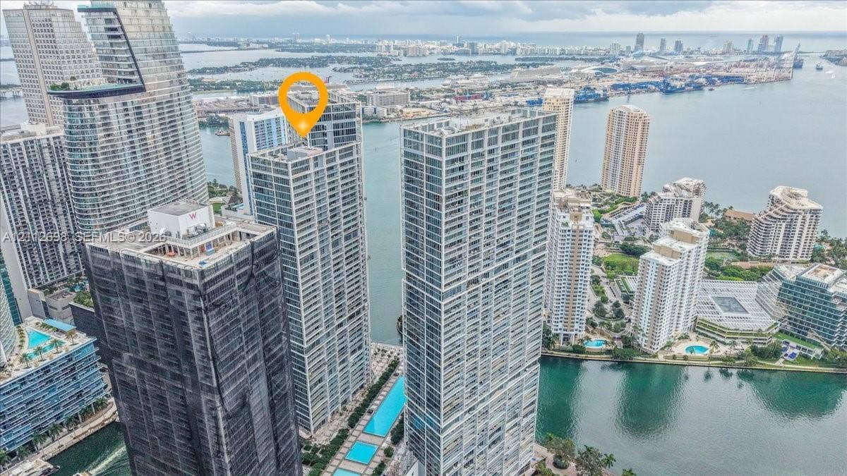 475 Brickell Avenue, #4511, Miami, FL 33131 High-rise glass facade residential tower positioned along a coastal waterway, featuring expansive balconies, integrated rooftop pool decks, and floor-to-ceiling glass windows