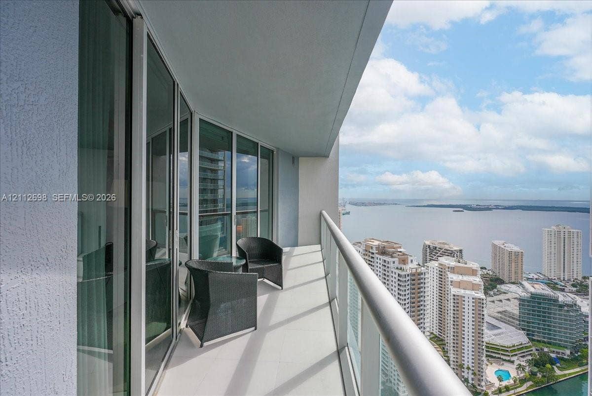 475 Brickell Avenue, #4511, Miami, FL 33131 Covered balcony featuring floor-to-ceiling glass doors, a metal railing, and high-rise water and cityscape orientation