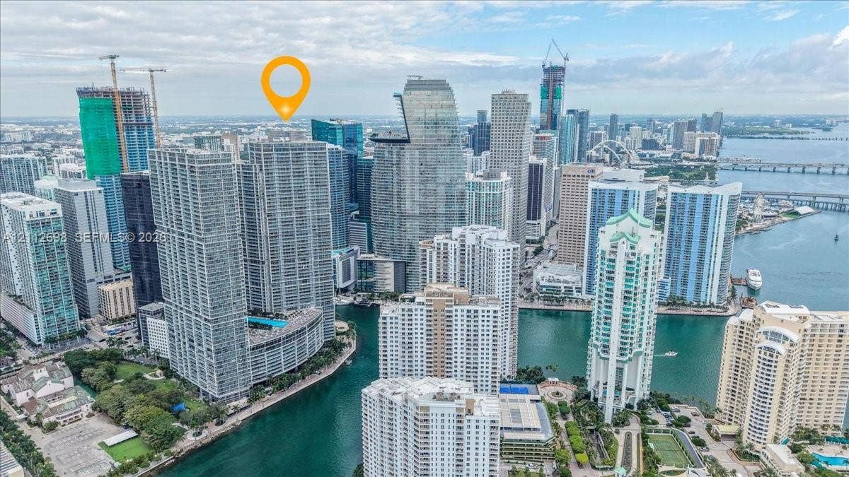 475 Brickell Avenue, #4511, Miami, FL 33131 High-rise residential tower featuring a glass-facade exterior and a podium-level swimming pool, situated within a dense urban waterfront landscape